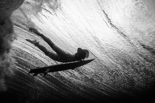 Underwater view of a surfer duck diving a wave in Lanzarote island. The Canary Islands, Spain. - Powered by Adobe