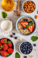 Fototapeta na wymiar Healthy breakfast - a bowl of oatmeal, berries and fruit, top view.