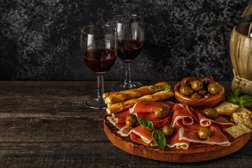 Prosciutto, cracker, bread sticks with red wine.