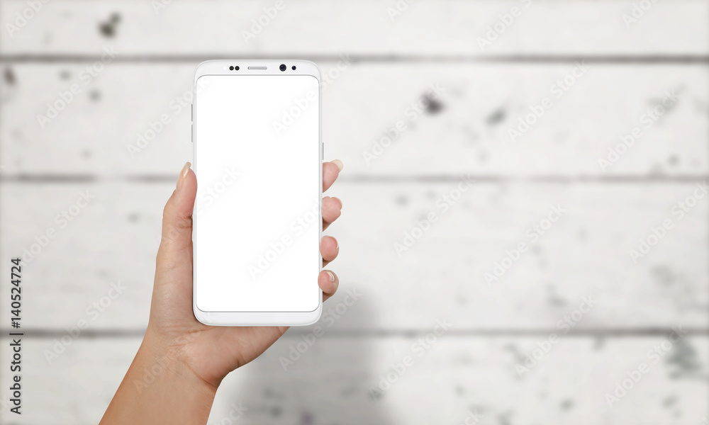 Aufkleber Woman showing smart phone with round edges. Moder phone with isolated screen for mockup. White wooden desk in background.
