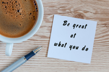 Be great at what you do - motivational concept in notepad with morning mug of coffee