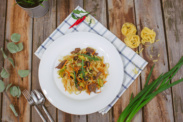 Pasta with olive meat greens on a white plate
