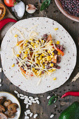 Vegetables, beans and cheese over tortilla bread - vegetarian mexican salad tacos.