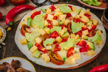 Tortilla with salad over it, surrounded by ingredients.