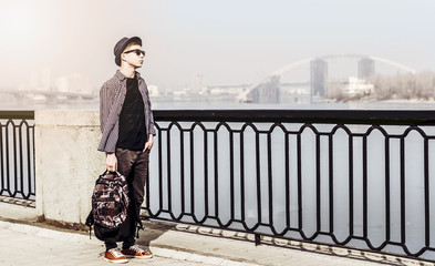 Obraz premium Stylish young man on the city embankment
