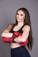 Portrait of a young woman boxer wearing red boxing gloves
