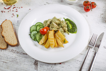 Chicken and potatoes with pickled cucumbers, greens