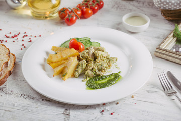 Chicken and potatoes with pickled cucumbers, greens