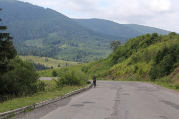 Fototapeta premium A Man Walking along the Road. The Mountains. Woodcutter.