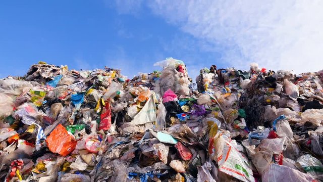 Empty bottles, plastic in the waste dump. Big piles of garbage. Dolly shot. 4K.