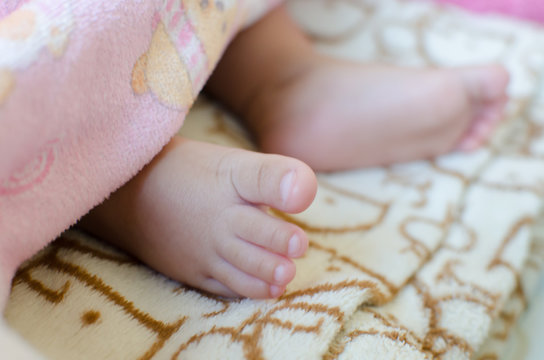 Close up of Innocent Feet Baby Soft Skin under  
blanket. Soft Focus and Soft Tone.