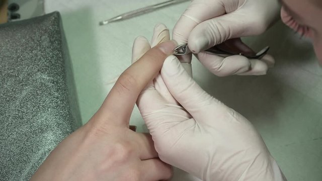Closeup of manicure master cutting the cuticula