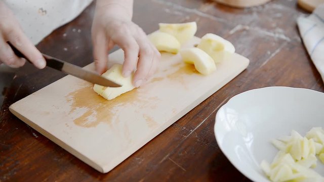 Cooks fresh juicy apples on a wooden board