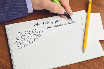 Man shows presentation of business concepts network marketing and business structures diagram in notepad on the table.