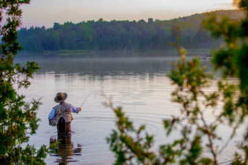 Fototapeta na wymiar Young man flyfishing at sunrise