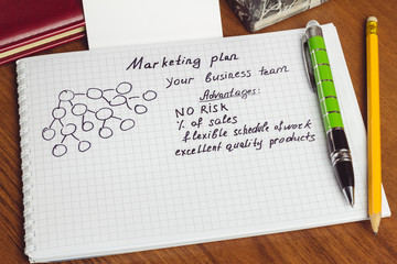 Presentation of business concepts network marketing and business structures diagram, advantages in notepad on the table.