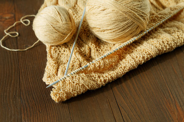 Knitting spokes with ball of wool on table