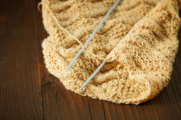 Knitting spokes with ball of wool on table