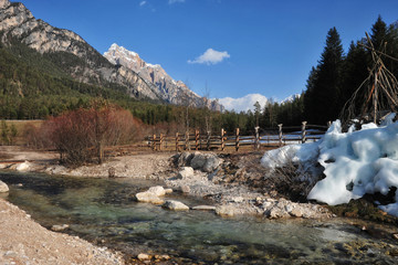 Landscape of Dolomites mountains in summer with a river and trees