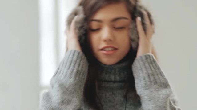 Teen girl in fluffy earphones listen music