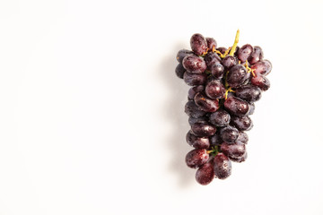 Bunch of red grapes with water drops on light background