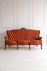 Vintage leather sofa on a wooden floor white stucco on a white background