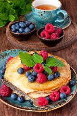 Crepes with  fresh berries. Pancakes stack with raspberry,, blueberry and syrup