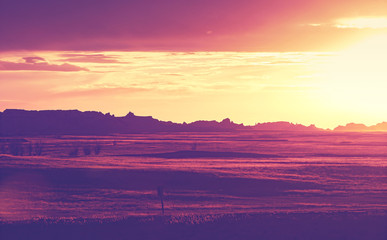 Vintage toned rock silhouettes in Badlands National Park at sunset, South Dakota, USA.