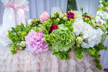 The table of the newlyweds decorated with pink hydrangeas and green colors, bright and juicy hydrangea