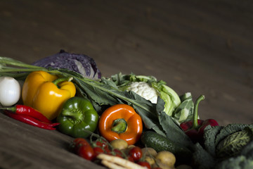 Young spring vegetables on black wood. Background with place for text
