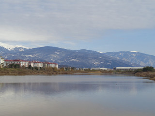 Fototapeta na wymiar Озеро на фоне гор, здания отелей на берегу