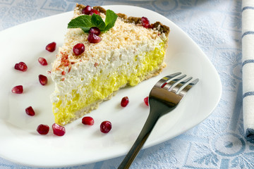 Homemade coconut cream pie and pomegranate seeds in white plate