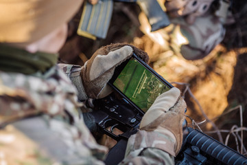 soldiers holding gps in hand and determines the location of coordinates
