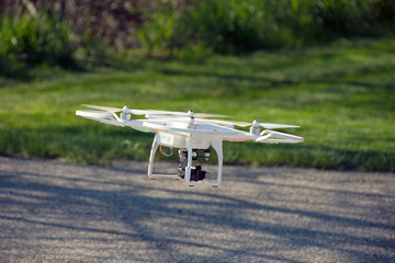 drone with video camera hovering over street pavement