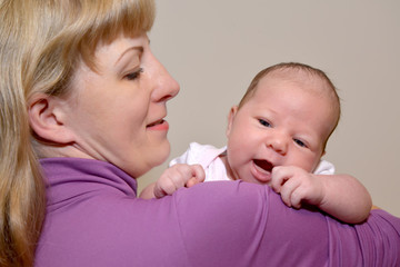 Portrait of the young woman with the cheerful baby on hands