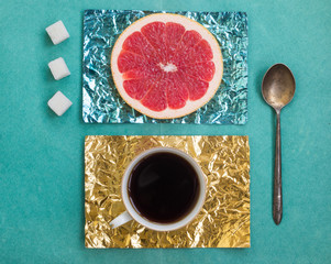 Orange slice and a cup of coffee on stands made of colored foil
