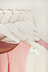 Women's clothing in pink tones on a white hanger.