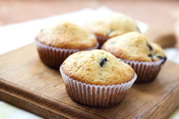 Homemade muffins with blueberries on a wooden board
