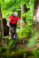 Fototapeta na wymiar Couple Mountain Biking on Single Track in the Forest