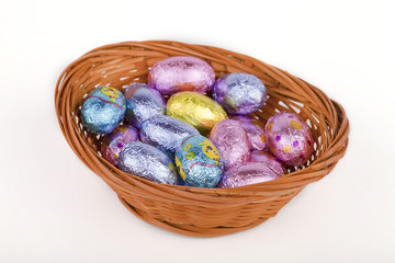 Colorful Easter eggs in a basket isolated on white