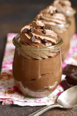 Chocolate mousse with whipped cream in a vintage glass jar.