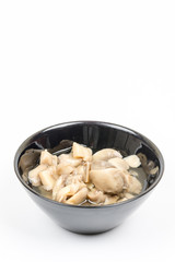 Sliced marinated mushrooms in the bowl isolated over white background