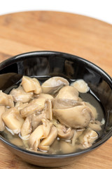 Sliced marinated mushrooms in the bowl isolated over white background