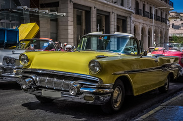 Fototapeta na wymiar Gelber amerikanischer Cabriolet Oldtimer parkt in der Seitenstraße in Havanna Kuba - Serie Kuba Reportage