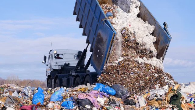 4K. Truck offloading waste into a huge landfill. 4K.