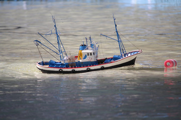 Naklejka na ściany i meble Model boat floats in the pool. Ship modeling