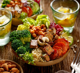 Fototapeta na wymiar Healthy salad with a variety of vegetables, broccoli, sweet potatoes, chickpeas, beets, avocados, tofu with the addition of cashew nuts and sunflower seeds