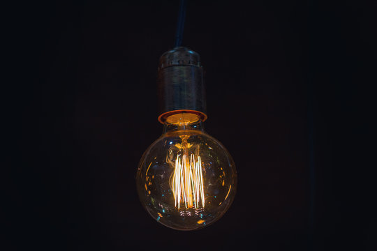 Vintage incandescent lamp hanging on a dark background