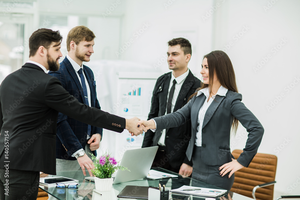 Wall mural handshake of business partners after signing the contract in the