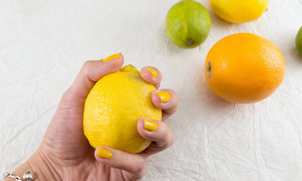 Female hand holding lemon on a table